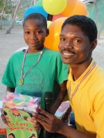 Seen here the Kids' EE Haiti Director Pastor Pierre Banes Laurore distributing the Make Jesus Smile shoeboxes. Used as the conduit to activate the child sponsorship program.
