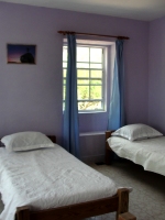 The east facing bedroom has five single beds. There are distant views of Skeetes Bay and the room is cooled by tropical sea breezes. 