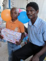 Seen here a Haitian orphan at Maranatha Ministries in St Marc receiving his shoebox gift packed by the children at Eden Lodge Primary School 