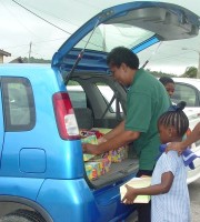 Paulette Scantlebury helping pack the boxes into the car ready for shipment