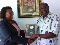 Seen here Dr Veronica Evelyn presenting an Appreciation Award to the Director of PCF Uganda, Mr. Lawrence Lugwana